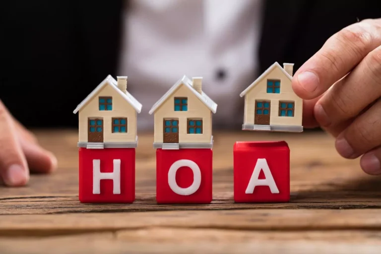 Hands constructing a stable structure with toy houses and blocks, representing the solid operational and financial foundation Davo provides for HOAs