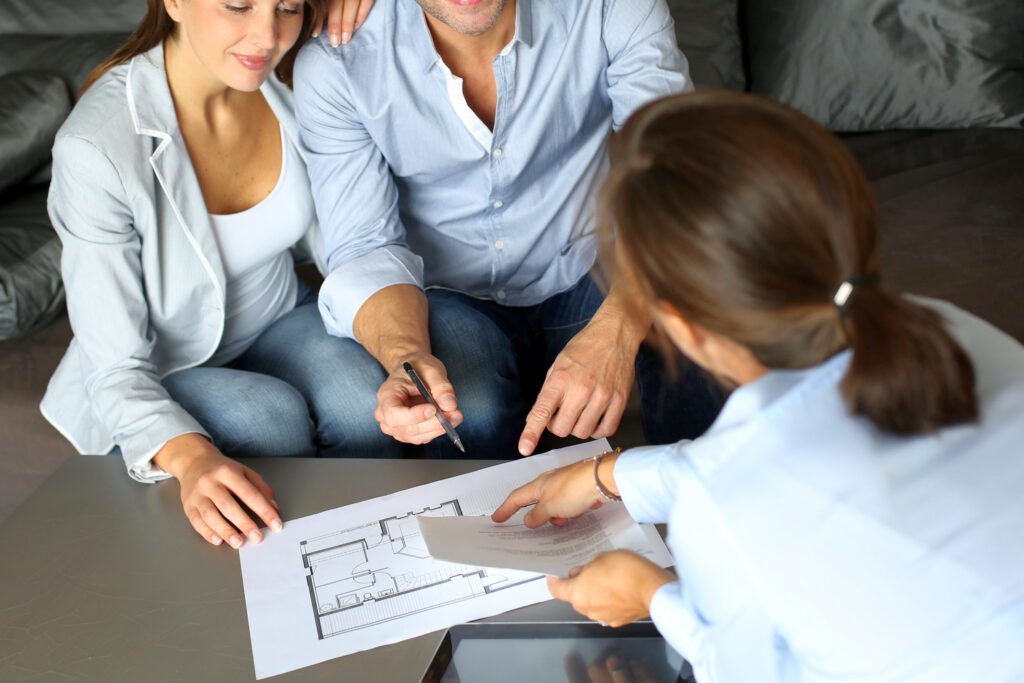 Property manager meeting with homeowners reviewing floor plan and documents